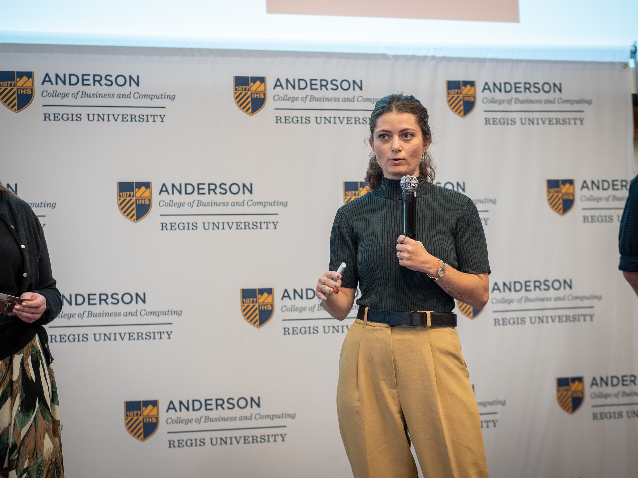 Lana McClure pitches Tot Friendly Homes in front of the Anderson College backdrop.