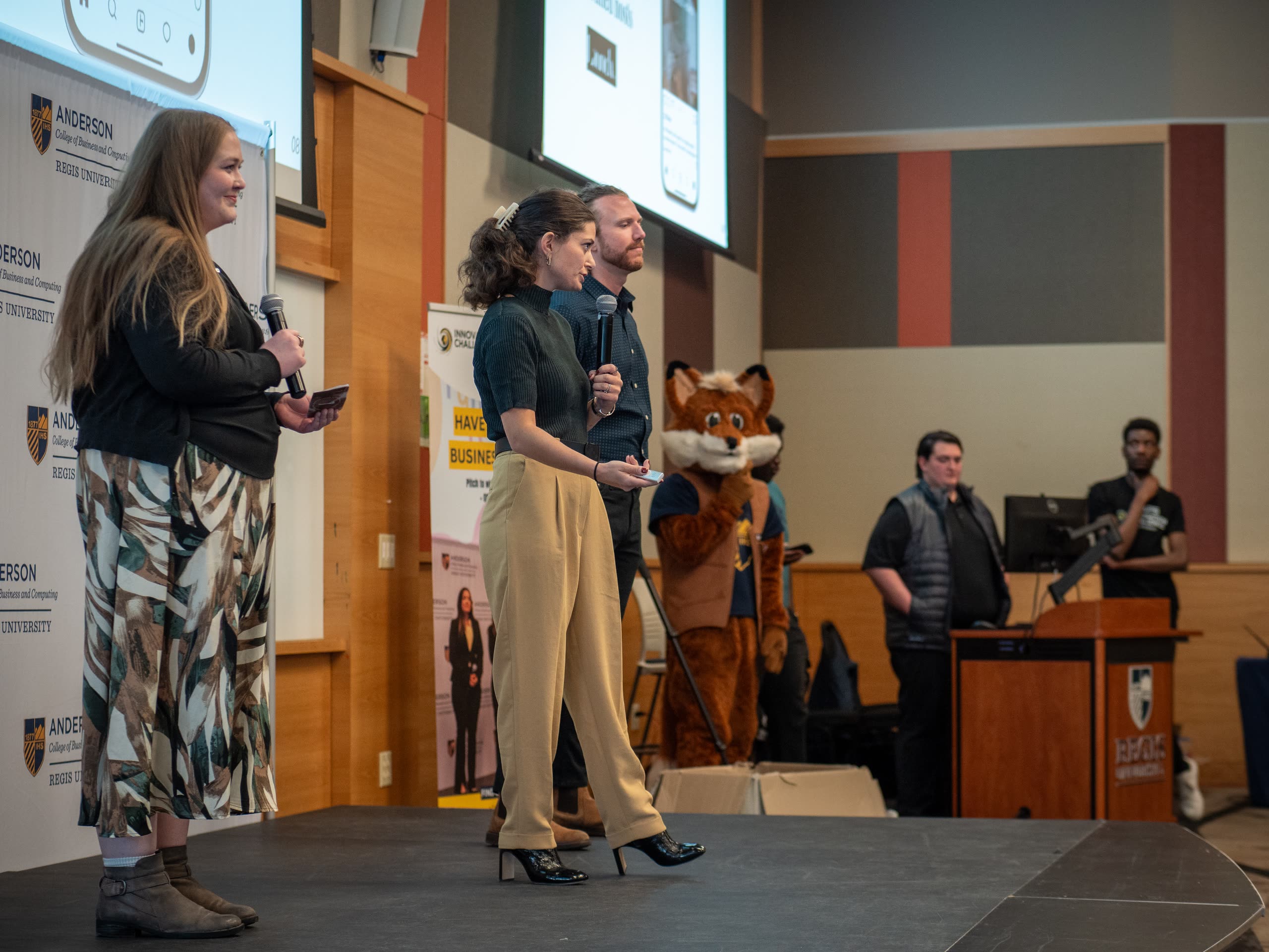 Emmie Heiserman and Lana McClure present Tot Friendly Homes on stage, with Chapin Griffith behind them.