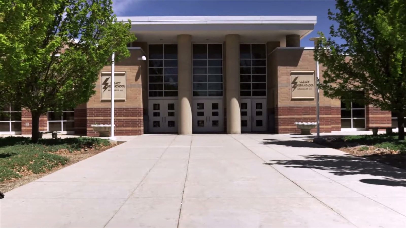 The front doors of Legacy High School in Broomfield, Colorado, on a sunny day.