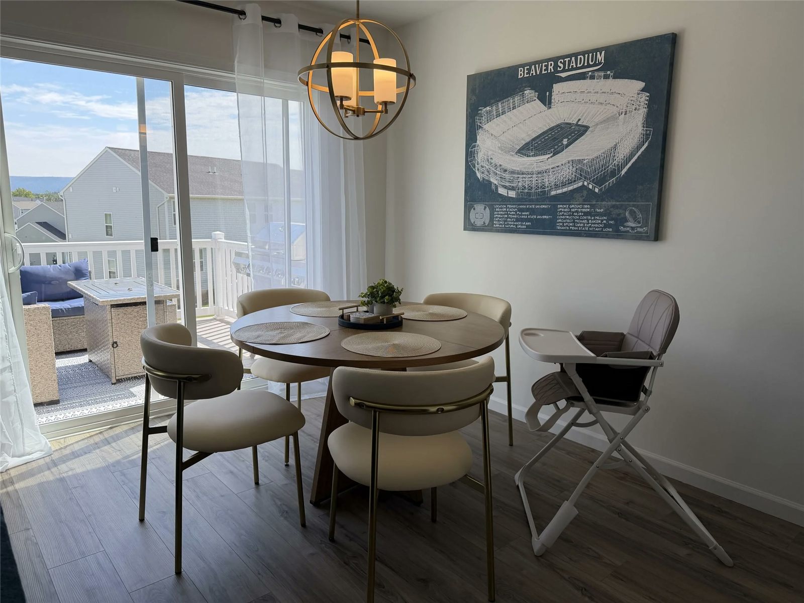 A round dining table by a sliding door, with a high chair pulled up beside it, in a Tot Friendly Homes certified home.